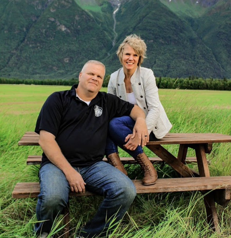 Rob and Linda sitting on a picnic table in Alaska